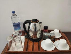 ein Holztablett mit einer Kaffeemaschine und einer Flasche Wasser in der Unterkunft Ceylon Elegant in Ella