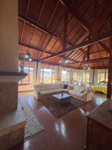 a large living room with two couches and a table at Estalagem Fernandes in Monte Verde