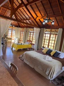 a bedroom with a large bed in a room with windows at Estalagem Fernandes in Monte Verde