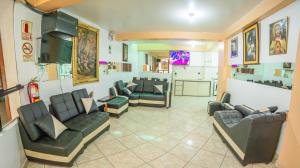 Una sala de espera con sofás y sillas y un televisor. en VILLA andina cusco, en Cusco