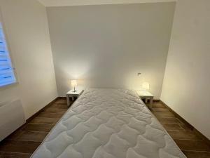 a large bed in a room with two side tables at Maison de Campagne de Charme à Bellevigny in Saligny
