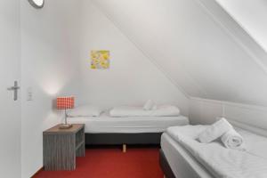 una camera da letto con due letti e un tavolo con una lampada di Landal Winterberg a Winterberg Altre 29 foto