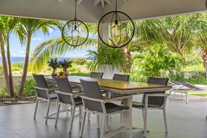 a dining room with a table and chairs and palm trees at Stylish 3 Bedroom Villa With Ocean Views And Daily Maid Service in Willemstad