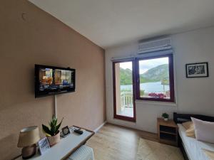 a living room with a couch and a large window at Visit Dreznica - Canyon Retreat in Mostar