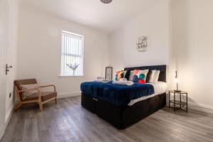 um quarto com uma cama, uma cadeira e uma janela em Jesmond Stylish 3Bedroom House Close City Centre em Jesmond