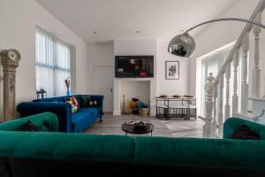 uma sala de estar com sofás azuis e uma TV em Jesmond Stylish 3Bedroom House Close City Centre em Jesmond