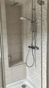 a shower with a glass door in a bathroom at Schöne moderne Ferienwohnung in Bordelum +16 photos