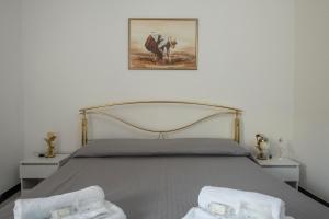 a bedroom with a bed with two white towels on it at Ca' de Nina, nel cuore di Moneglia a pochi passi dal Mare in Moneglia