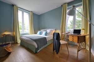 a bedroom with a bed and a desk with a laptop at Hôtel Le Saint Christophe in La Baule