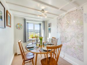 a dining room with a table and a map on the wall at Hyfrydle Cottage in Pen-y-groes