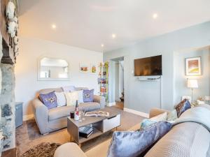 a living room with a couch and a table at Hyfrydle Cottage in Pen-y-groes