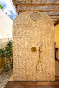 una ducha en una pared de ladrillo con cabezal de ducha en Villa Summer - Seasons, en Uluwatu 33 fotos más