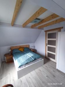 Un dormitorio con una cama en una habitación con techos de madera. en Baltic Rafa, en Niechorze