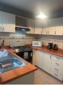 a kitchen with a sink and a stove and a microwave at Miraflores Moonlight in Lima