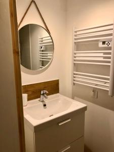 une salle de bains avec un lavabo blanc et un miroir dans l'établissement L'Aire des montagnes, à Bolquère-Pyrénées 2000