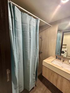 JatiraranganLovely Studio Unit in Orange County的带浴帘和水槽的浴室