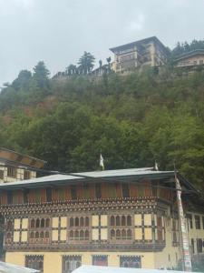 Un edificio en la cima de una colina con casas encima. en Sompal Serviced Apartment, en Paro