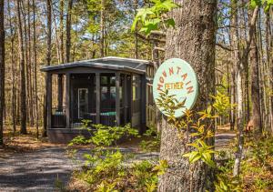 une cabane dans les bois avec un panneau sur un arbre dans l'établissement Mt Fether - Tiny Home - Mins to DeSoto, Brow Park, à Mentone