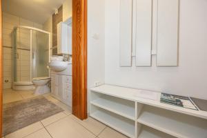 a white bathroom with a toilet and a sink at Apartments Villa Residenca in Novi Vinodolski +74 photos