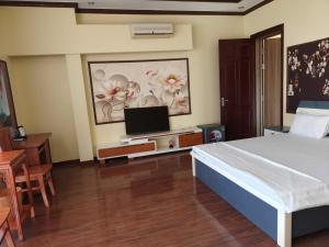 a bedroom with a bed and a flat screen tv at Đức Anh Hotel Ninh Binh in Ða Gia
