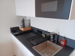 a kitchen counter with a sink and a microwave at Studio Sol Y Mar Westende in Westende Bad