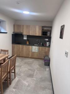 a kitchen with wooden cabinets and a table and chairs at Penzión U Vinca in Banská Bystrica