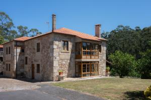a large stone house with two chimneys on top at Casa de Trillo Galitrips in Rego de Santa Marina