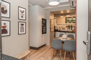 uma cozinha e sala de jantar com mesa e cadeiras em Tova Pearl - Cozy, Modern 2BR Apt, DT, Ultracentral, Chabad across street, 20 min walk to Old Town em Bucareste