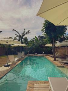a swimming pool with chairs and umbrellas at Namal Resort - Free scooter and Gym access in El Nido