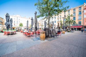 a street with tables and chairs and umbrellas at Coronell d'En Vila in Perpignan