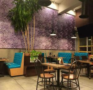 a restaurant with tables and chairs and a purple wall at Casa MODERNA MALECON PLAYA in Coatzacoalcos