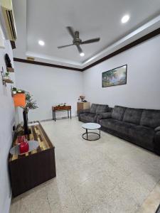 a living room with a couch and a table at PD Shell Gate Home Stay in Port Dickson
