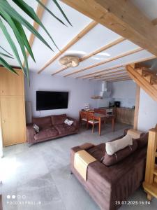 a living room with a couch and a flat screen tv at Baltic Rafa in Niechorze
