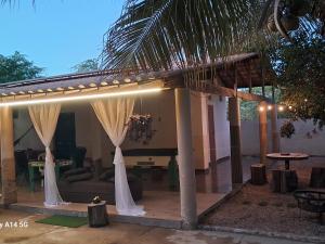 a pavilion with white curtains and a living room at Chalé Brisas do rio espaço privativo ideal para casal ou família in Petrolina