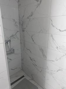 a bathroom with a shower with white marble walls at Penzión U Vinca in Banská Bystrica +24 photos