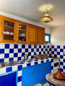 a kitchen with blue and white checkered counter top at The blue house in Taghazout