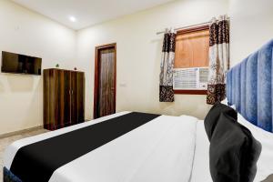 a bedroom with a bed and a window at Hotel O YUVI in New Delhi