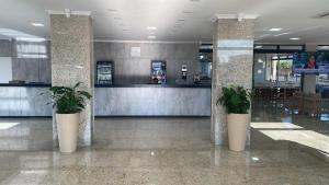 a lobby with two potted plants in a building at D` Garcia Hotel in Três Lagoas