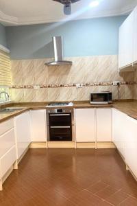 a kitchen with a stove and a microwave at Relaxation Retreat in Koforidua in Koforidua
