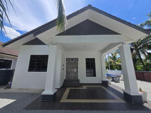 a small white house with a black roof at Senjaloka Homestay SWIMMING POOL in Bachok
