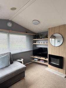a living room with a couch and a television at Padstow Holiday Base Bright Two Bedroom Lodge at Seven Bays in St Merryn