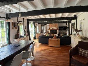 a living room with a large wooden table and chairs at Lazy Lane in Gruchet-Saint-Siméon