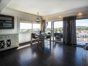 a dining room with a table and some windows at Atalaya Apartment by Hello Homes Sitges in Sitges