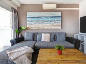 a living room with a couch and a table at Atalaya Apartment by Hello Homes Sitges in Sitges