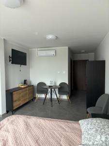 a bedroom with a table and chairs and a tv at Apartament-Zdrojowa 27 in Gołdap