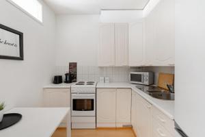 a white kitchen with white cabinets and a sink at Scandinavian Home 1BR Unbeatable Central Location 26 in Helsinki