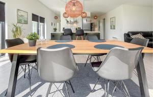 a dining room with a wooden table and chairs at Holiday Home Pilemose Ii in Skovby