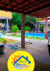 a patio with a sign in front of a pool at ChacaraSophya in Aquiraz