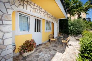 a patio outside of a house with a table and chairs at Apartment Dolores in Opatija