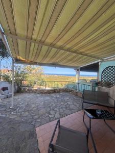 タナウネッラにあるVista Mare Houseの大きな傘とテーブルと椅子のあるパティオ